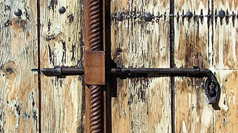 Rusty metal latch on weathered wooden door