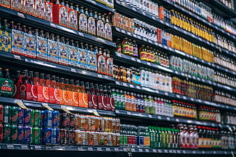 Colorful Beverage Aisle In Supermarket With Shelves Of Soda Bottles And Cans