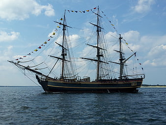 Historic Three-Masted Tall Ship Sailing on Blue Sea
