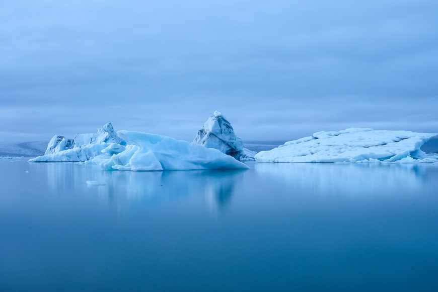 Serene Blue Icebergs Floating in Calm Arctic Waters
