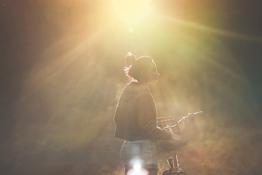 Backlit Woman with Bicycle in Golden Sunlight