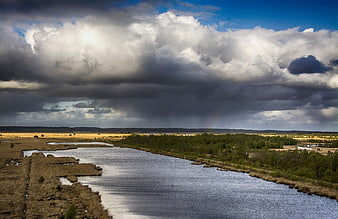 Dramatic Storm Clouds Over River and Wetlands Landscape