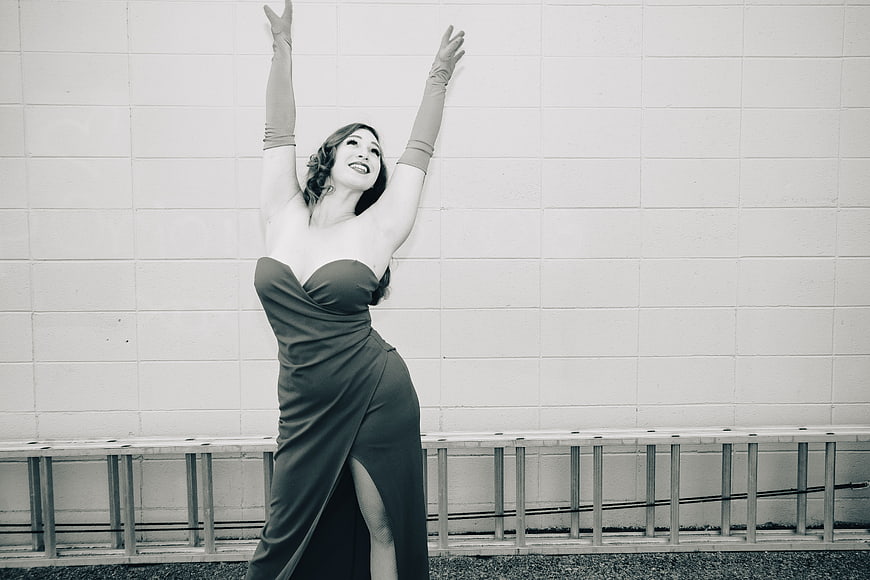 Vintage woman in elegant dress posing against wall