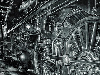 Black and white close-up of vintage steam locomotive wheels and mechanical parts