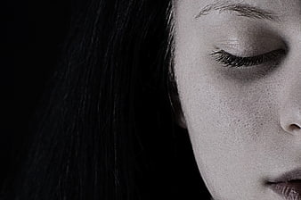 Close-up of woman's face with closed eyes in black and white