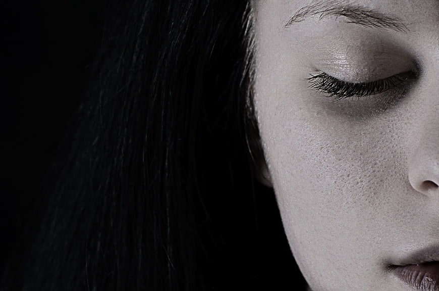 Close-up of woman's face with closed eyes in black and white