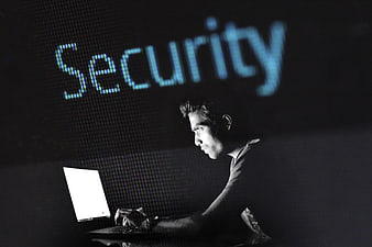 Man typing on laptop with security text projection