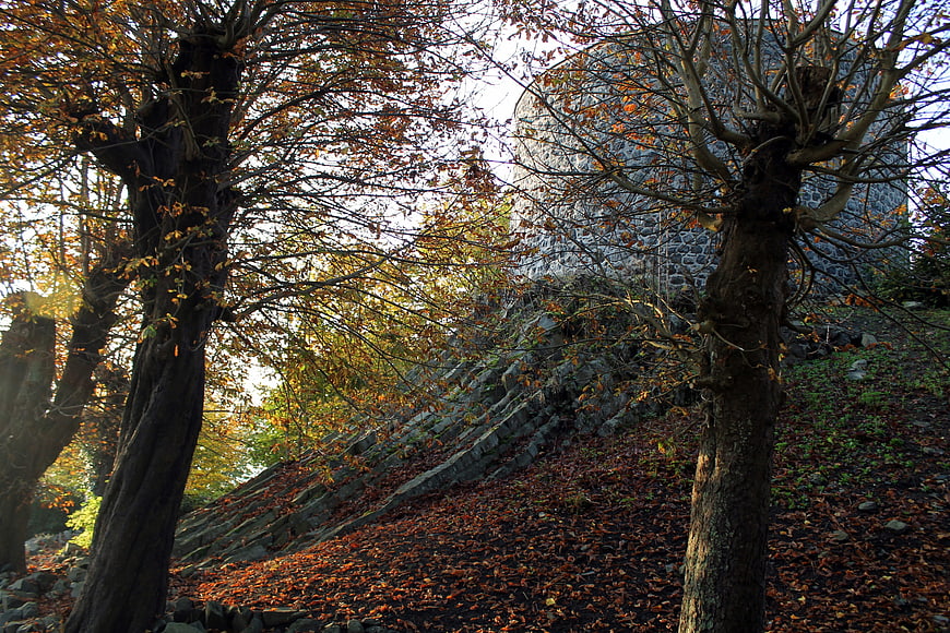 Autumn trees framing ancient basalt castle ruins in Westerwald
