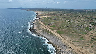 Aerial View of Rocky Coastline and Ocean Waves