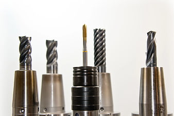 Assortment of CNC milling cutters and drill bits on white background