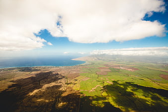 Aerial View of Green Fields, Ocean Coastline, and Cloud Shadows