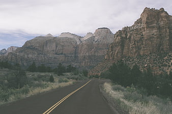 Winding road through desert canyon landscape with mountains