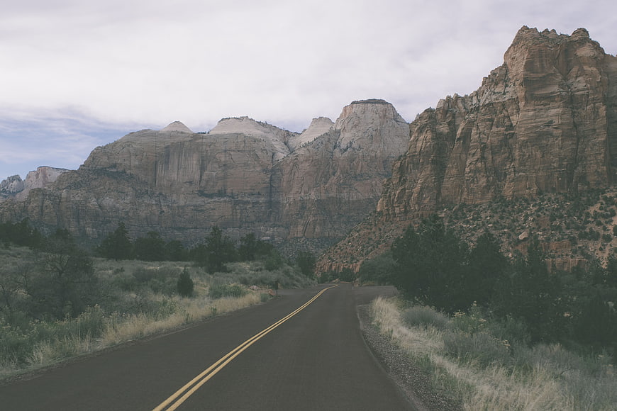 Winding road through desert canyon landscape with mountains