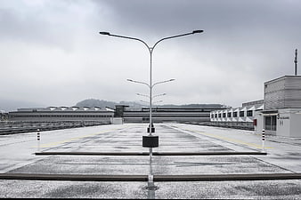 Symmetrical view of empty rooftop parking lot with street lamps