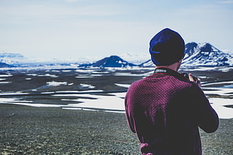 Photographer capturing snowy mountain landscape in winter