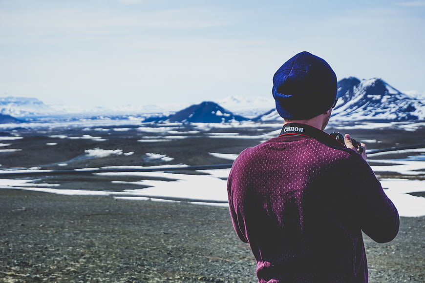 Photographer capturing snowy mountain landscape in winter
