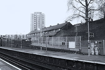 Black and white urban train station with tracks and buildings
