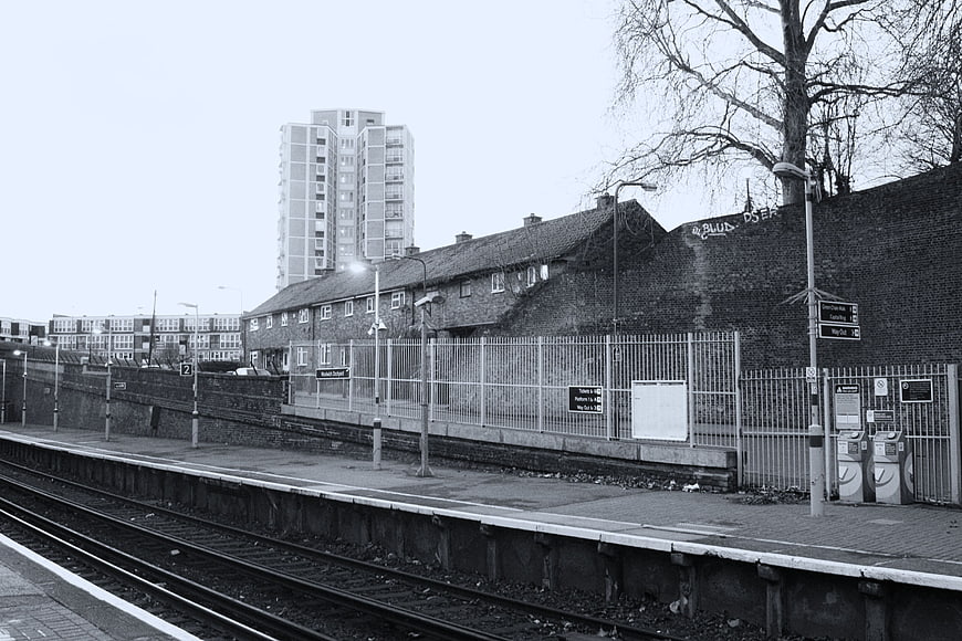 Black and white urban train station with tracks and buildings