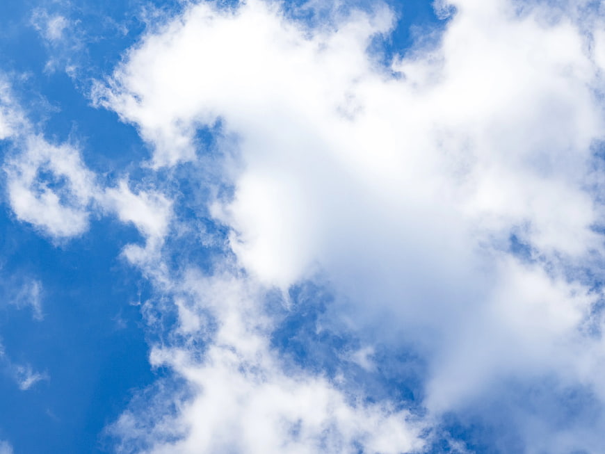 White Fluffy Clouds in Bright Blue Sky Background