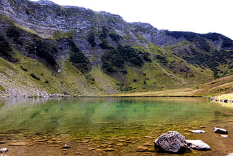 Serene Alpine Lake with Rocky Mountain Slopes