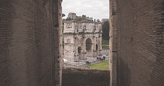 Arch of Constantine framed by ancient Roman brick walls
