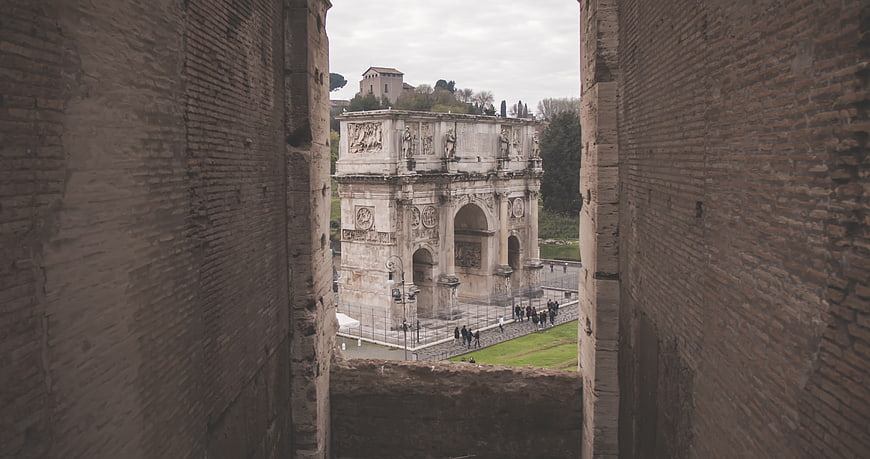 Arch of Constantine framed by ancient Roman brick walls
