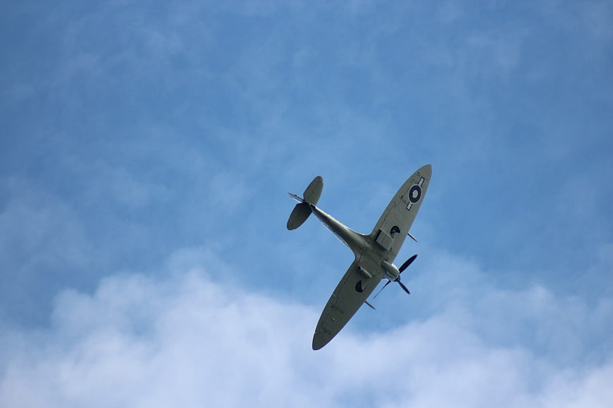 Vintage propeller airplane flying against blue sky