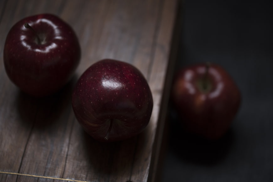 Three Red Apples on Wooden Surface
