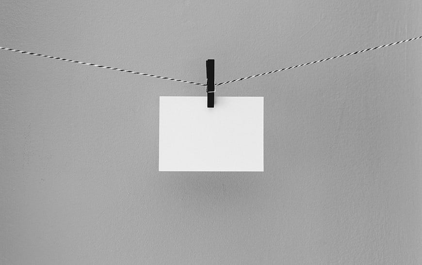 Minimalist blank white card hanging on twine with black clip