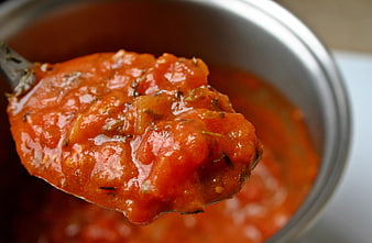 Close-up of homemade tomato sauce with herbs on a spoon
