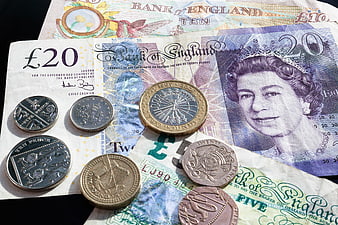 British Pound Sterling Banknotes and Coins on Black Background