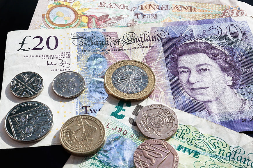 British Pound Sterling Banknotes and Coins on Black Background