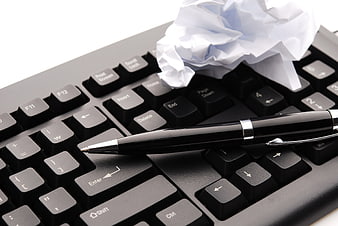 Black pen and crumpled paper on computer keyboard