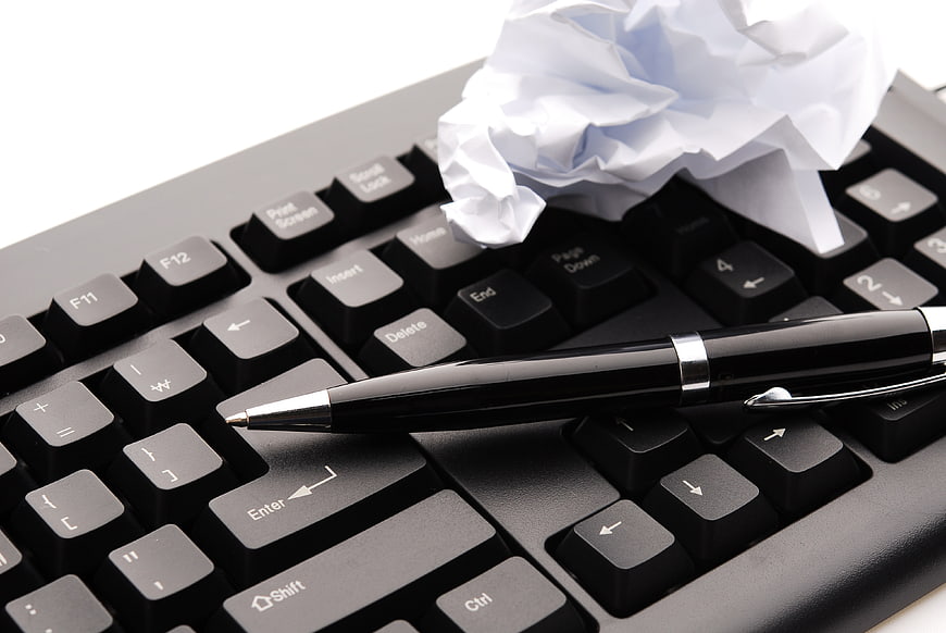 Black pen and crumpled paper on computer keyboard