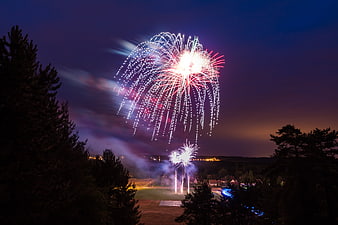 Fireworks Display Over Rural Landscape At Night