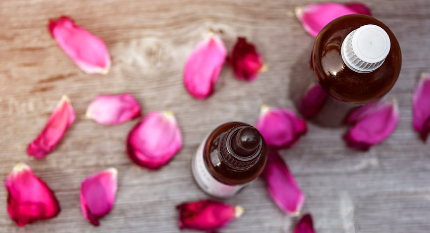 Top View of Essential Oil Bottles with Rose Petals