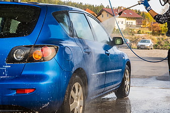 Blue Mazda Car Being Washed with High-Pressure Water Hose
