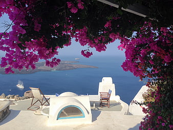 Santorini terrace with vibrant pink bougainvillea framing a blue sea view