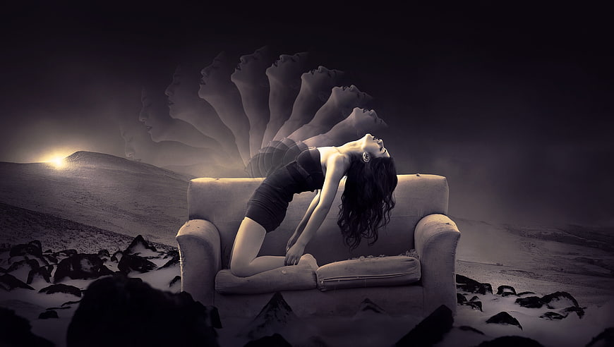 Woman on couch with ghostly heads in surreal landscape