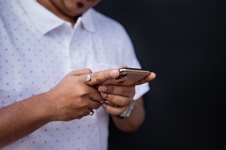 Man in White Shirt Using Smartphone