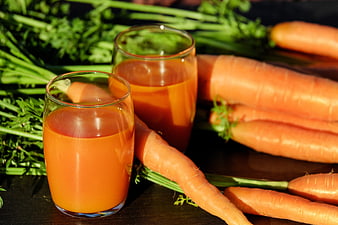 Fresh Carrot Juice in Glasses with Raw Carrots