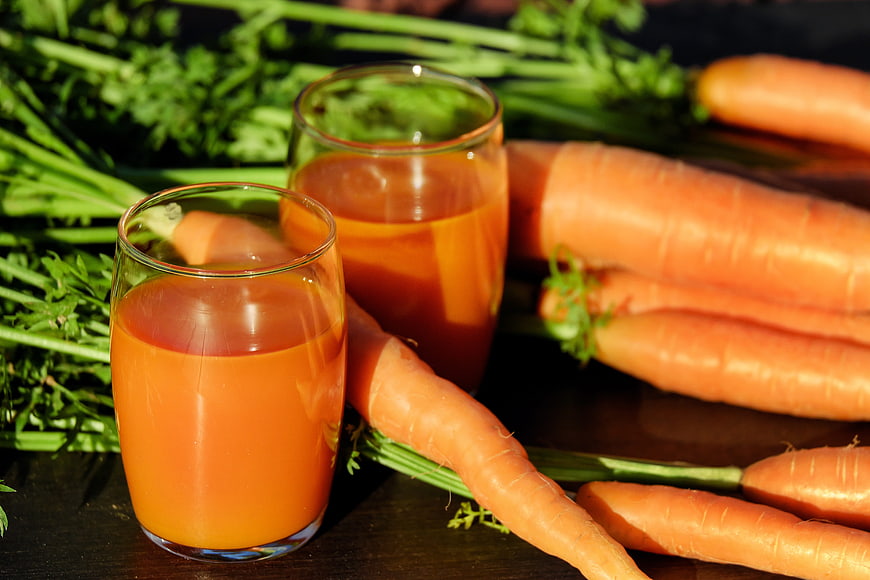 Fresh Carrot Juice in Glasses with Raw Carrots
