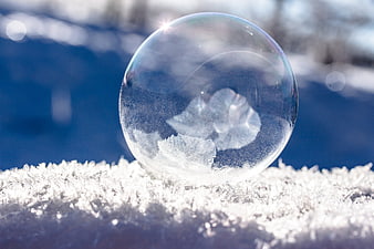 Frozen Soap Bubble with Ice Crystals on Snow