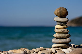 Stacked Beach Stones on Pebble Shore with Ocean Background