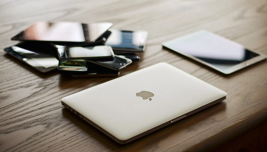 White MacBook and Tablets on Wooden Desk