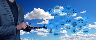 Businessman Holding Tablet With Cloud Computing Icons Against Blue Sky
