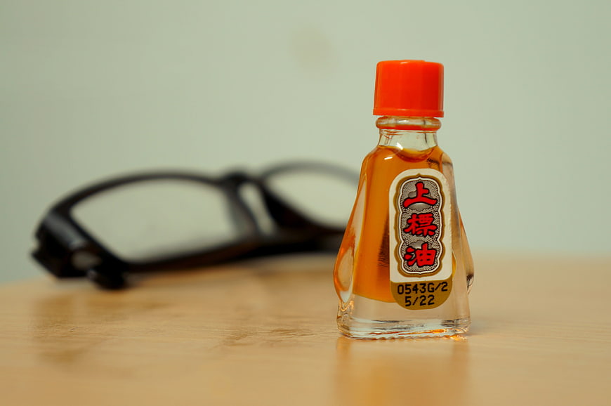 Small bottle of traditional Chinese hot oil medicine on wooden table