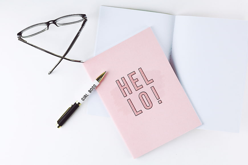 Pink Hello Notebook, Glasses, and Girl Boss Pen Flat Lay