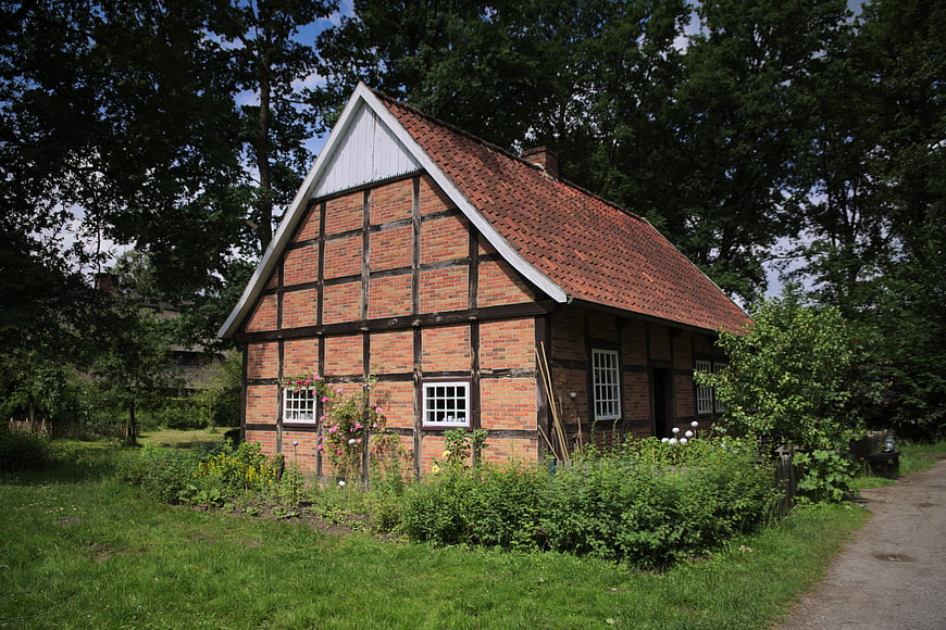 Traditional half-timbered brick cottage in summer garden