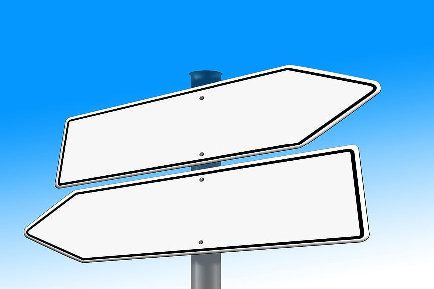 Blank White Directional Signpost Against Blue Sky